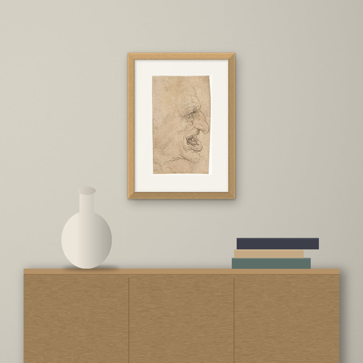 Head of a Grotesque Man – framed on a wall above a sideboard
