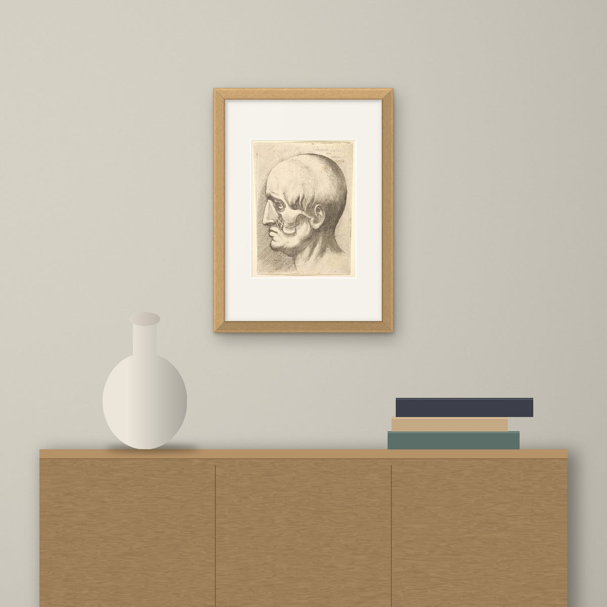 Male Head with Muscles Exposed – framed on a wall above a sideboard